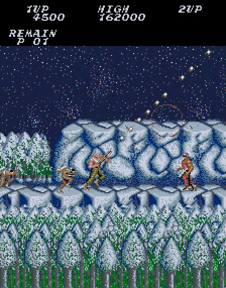 A low resolution screenshot of an icy platform with snow-covered trees in the foreground, another icy platform in the background, a muscular man shooting projectiles up at a 45-degree angle and enemies in front and behind him.