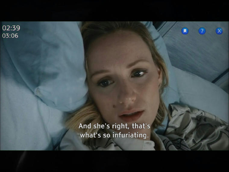 A white woman lying in bed apparently talking to someone on the phone. The subtitles say: "And she's right, that's what's so infuriating"
